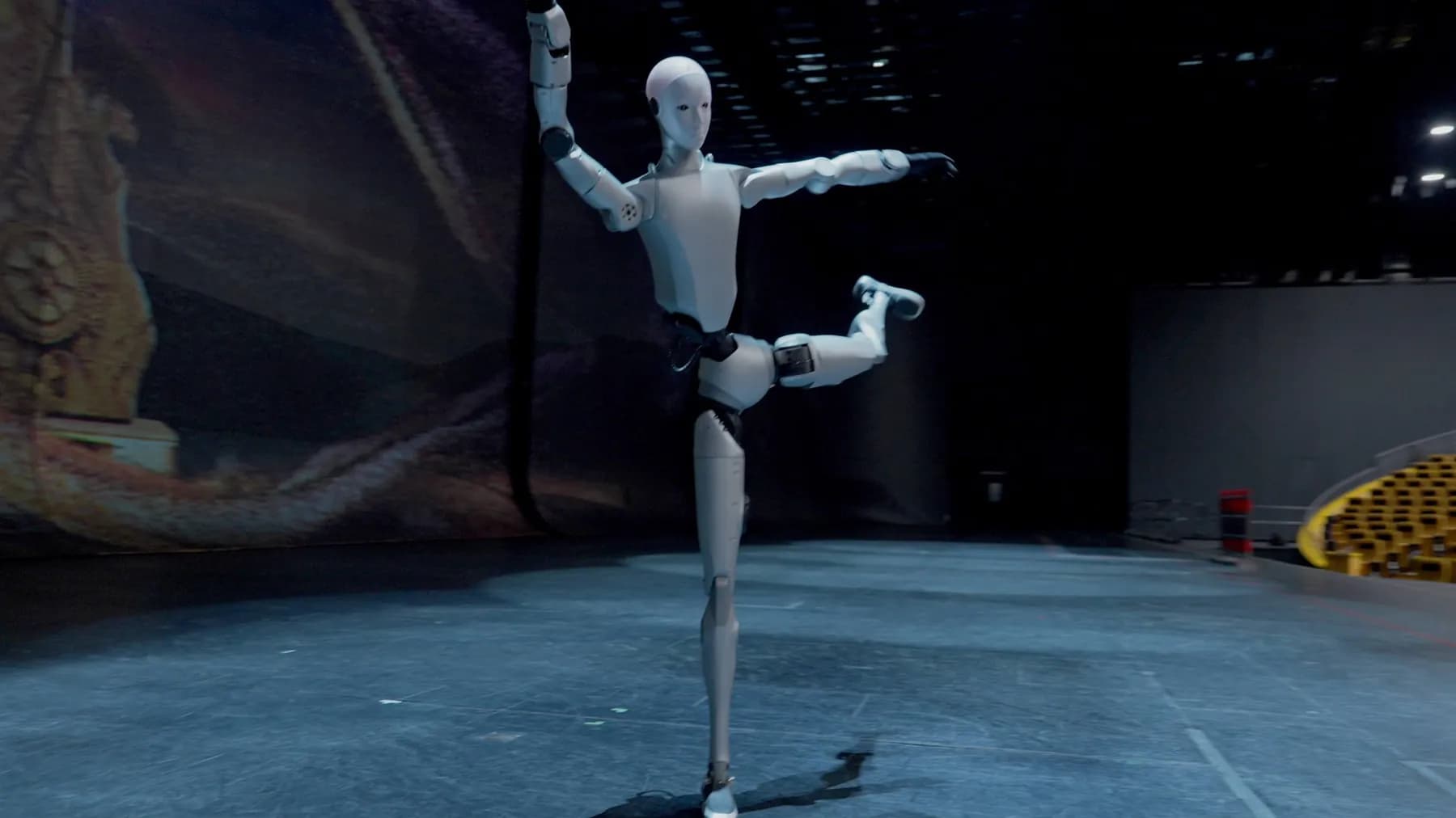 The Unitree H2 robot in a dance pose, on a dark stage