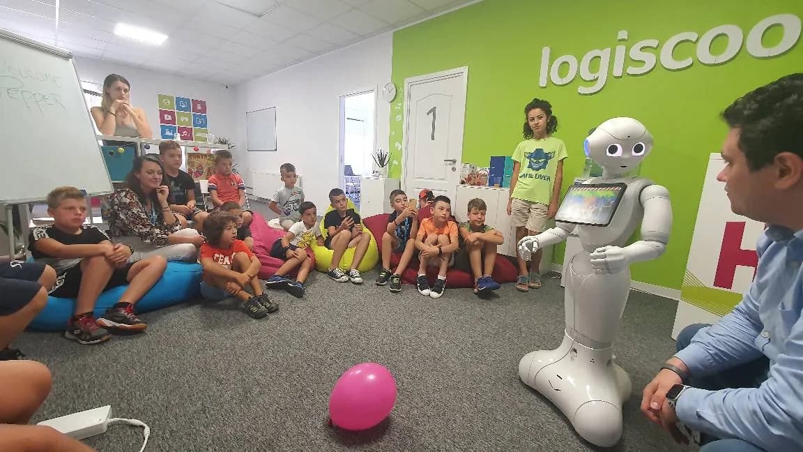 Children sitting on the floor listening to the Pepper robot