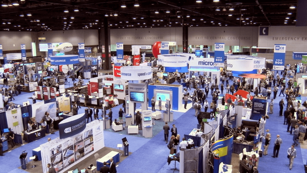 An exhibition hall full of stands and visitors, seen from above